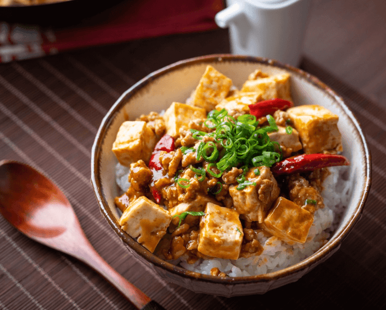 Donburi au tofu japonais, bol de riz garni de tofu mariné, champignons shiitake, carottes et œuf brouillé