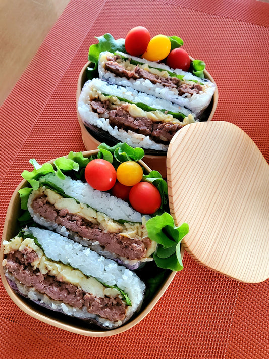 Onigirazu coupé en deux, sandwich au riz japonais garni de bœuf et d'œufs brouillés