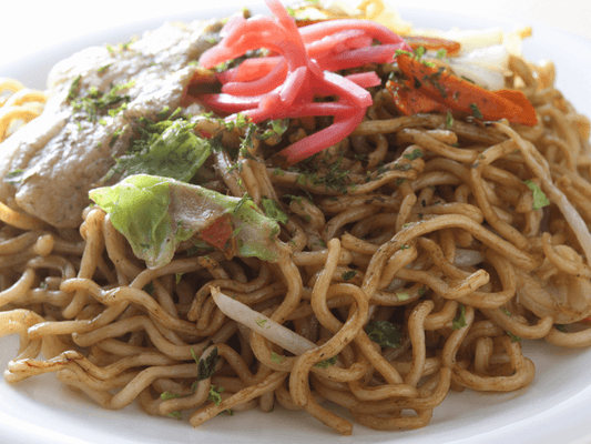 Yakisoba japonais classiques, nouilles sautées au porc et légumes nappées de sauce yakisoba, garnies d'aonori